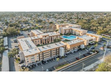 Expansive aerial view of a multi-unit residential community with a sparkling blue swimming pool at 5820 N Church Ave # 247, Tampa, FL 33614