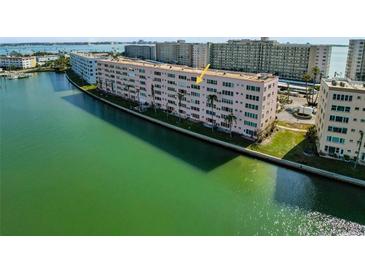 Aerial view of condo building on waterfront with pool and surrounding area at 6025 Shore S Blvd # 504, Gulfport, FL 33707