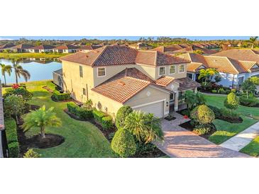 Stunning home featuring a tile roof, manicured landscaping, and a serene waterfront view at 6467 Willowshire Way, Bradenton, FL 34212