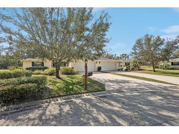 Inviting single-story home featuring a spacious driveway and well-manicured lawn with mature landscaping at 7161 Fairway Bend Cir, Sarasota, FL 34243