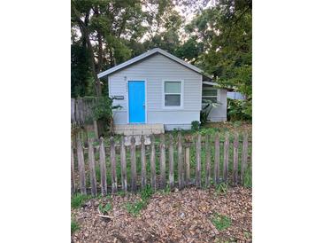 Gray house with blue door, picket fence, and small yard at 8004 N 11Th St, Tampa, FL 33604