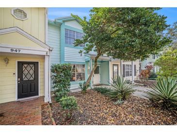 Two story light blue and yellow townhouses with mature landscaping at 949 Hamilton Ct, Palm Harbor, FL 34683