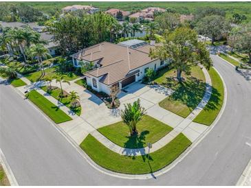 Expansive home with a circular driveway, lush landscaping, and screened in pool area at 5501 E Longboat Blvd, Tampa, FL 33615