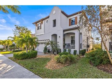 Stunning two-story home with lush landscaping, beautiful front lawn, and charming architectural details at 1021 Seagrape Dr, Ruskin, FL 33570