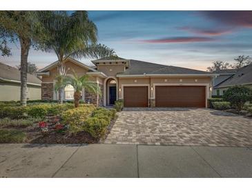 Two-story house with brown doors, paver driveway, and landscaped yard at 1045 Tracey Ann Loop, Seffner, FL 33584