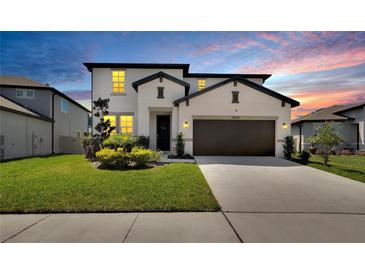 Beautiful two-story home features a manicured lawn, a two car garage, and a modern white facade at 13526 Palmera Vista Dr, Riverview, FL 33579