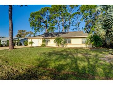 Single-story home with a well-manicured lawn and mature trees at 3241 Rogue St, North Port, FL 34291