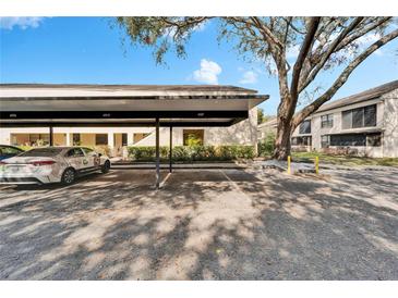 Assigned covered parking area in front of this well-maintained condominium complex with mature landscaping at 4917 Puritan Cir, Tampa, FL 33617