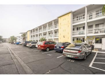 Building exterior showcases ample parking and multiple stories with charming white balconies for each unit at 5892 Easy St # L25, Bradenton, FL 34207