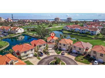 Aerial view of red-roofed homes on a manicured golf course with serene ponds and waterfront cityscape backdrop at 6105 Mirada Cir, St Petersburg, FL 33715