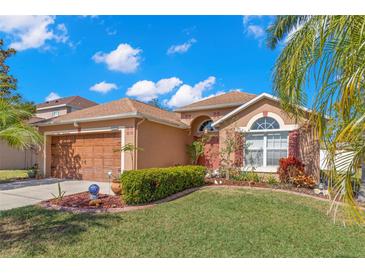 Charming single Gathering home featuring well-maintained landscaping, inviting curb appeal, and attached two-car garage at 6426 Gondola Dr, Riverview, FL 33578