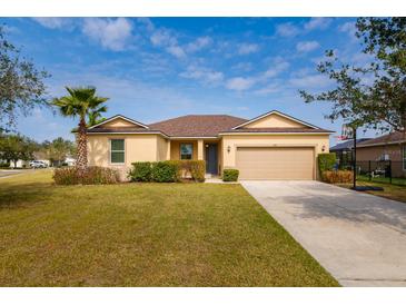 Charming single-story home featuring a well-manicured lawn, mature landscaping, and a two-car garage at 7304 63Rd E Ct, Palmetto, FL 34221