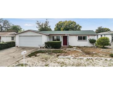 Charming single-story home featuring an attached garage and cozy front yard at 9121 Prosperity Ln, Port Richey, FL 34668