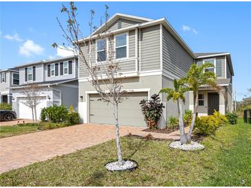 Charming two-story home with gray siding, a brick driveway, and lovely landscaping, inviting you to a comfortable suburban lifestyle at 11616 Little River Way, Parrish, FL 34219