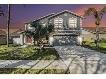 Charming two-story home featuring a well-maintained lawn, beautiful trees, and a spacious two car garage at 5914 Falconwood Pl, Lithia, FL 33547