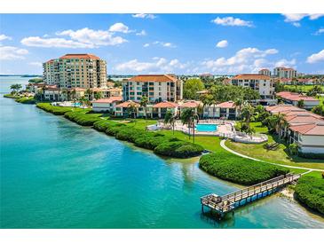 Beautiful aerial view of waterfront condos, featuring a long dock and pool, under blue skies at 6268 Palma Del Mar S Blvd # 101, St Petersburg, FL 33715