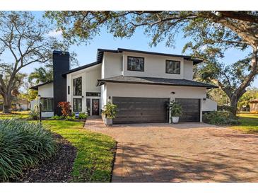 Charming two-story home with a three-car garage and landscaped front yard at 10098 Oaks Ln, Seminole, FL 33772