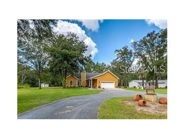 Charming single-story home with a well-manicured lawn and a long driveway at 11545 Kent Grove Dr, Spring Hill, FL 34610