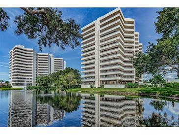 Beautiful shot of the high-rise condo complex with a serene lake and fountain in the foreground at 5940 Pelican Bay S Plz # Ph E, Gulfport, FL 33707