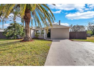 Charming single-story home featuring a well-maintained lawn and complemented by a mature palm tree at 6706 Sierra Ter, New Port Richey, FL 34652