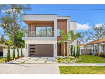 Stunning contemporary home featuring a balcony, wood accents, and a modern garage door at 910 W West St, Tampa, FL 33602