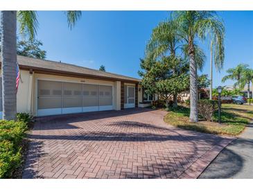 Charming home featuring a brick driveway, attached garage, and well-manicured landscaping at 2609 Locksley St, Sun City Center, FL 33573