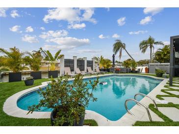 A stunning backyard oasis featuring a sparkling pool, lush landscaping, and lounge chairs for ultimate relaxation at 3934 Doral Dr, Tampa, FL 33634