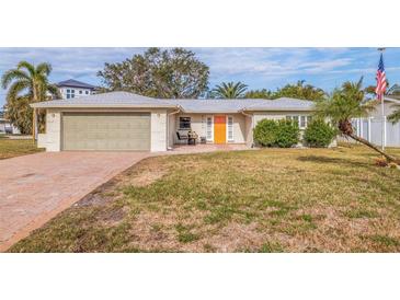 Charming single-story home with a well-manicured lawn and attached garage at 10100 Paradise Blvd, Treasure Island, FL 33706