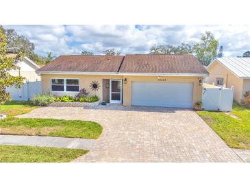 Charming one-story home featuring a brick driveway, two-car garage, and well-maintained landscaping at 10829 65Th N Way, Pinellas Park, FL 33782