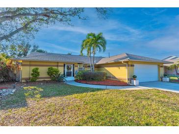 Charming single-story home with well-manicured lawn, mature trees, and a welcoming entryway at 12478 93Rd Way, Largo, FL 33773