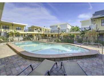 Inviting community pool with lounge chairs, set amidst beautifully maintained buildings and lush landscaping at 16333 Gulf Blvd # 105, St Petersburg, FL 33708