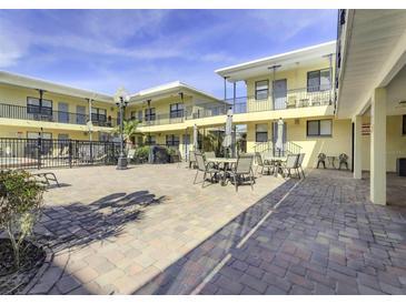 Community patio with tables and chairs near the pool at 16333 Gulf Blvd # 106, St Petersburg, FL 33708