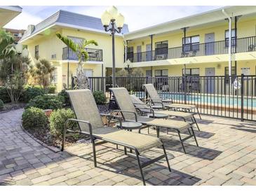 Relaxing poolside lounge chairs near the community pool at 16333 Gulf Blvd # 106, St Petersburg, FL 33708