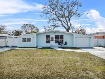 Charming single-story home with a well-manicured lawn, a quaint front porch, and a light blue facade at 4414 W Paris St, Tampa, FL 33614