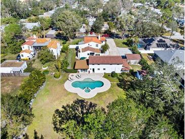 Stunning aerial view of a home featuring a unique clover-shaped pool, lush landscaping and beautiful tile roofs at 6010 17Th S Ave, Gulfport, FL 33707