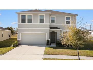 Charming two-story home featuring a manicured lawn, a two-car garage, and welcoming front entrance at 16733 Glacier Bay Loop, Wimauma, FL 33598