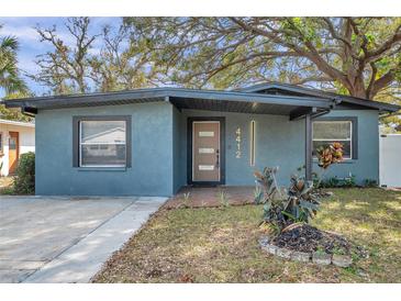 Recently updated home with a two-tone exterior, modern door, and front yard at 4412 W Pearl Ave, Tampa, FL 33611