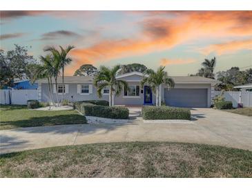 Charming single-story home featuring a manicured lawn, lush landscaping, and a welcoming front entrance at 4440 Huntington Ne St, St Petersburg, FL 33703