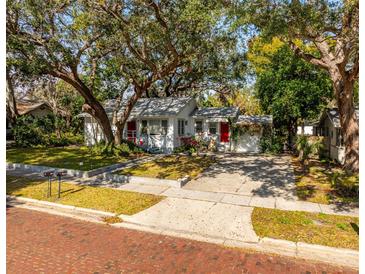 Charming single-story home with a well-manicured lawn and mature trees providing shade at 620 Scotland St, Dunedin, FL 34698