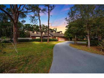 Charming home boasts a well-manicured lawn, mature trees, and a long driveway leading to the garage at 8730 143Rd N St, Seminole, FL 33776