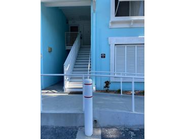 Aqua painted condo building with stairs leading to a second-story unit at 3730 42Nd S Way # K, St Petersburg, FL 33711
