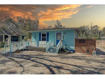 Charming blue house with a spacious brick driveway and inviting front porch at 6532 30Th N St, St Petersburg, FL 33702