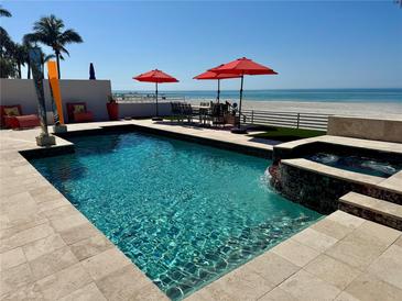 Backyard pool, hottub, and beach access with chairs and umbrellas at 1522 Gulf Blvd, Indian Rocks Beach, FL 33785