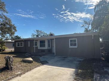 Charming single story home with a well-maintained front yard and a driveway on a sunny day at 1817 Meridel Ave, Tampa, FL 33612