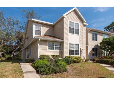 Charming two-story townhouse with light beige siding and well-maintained landscaping at 2105 Clover Hill Rd, Palm Harbor, FL 34683