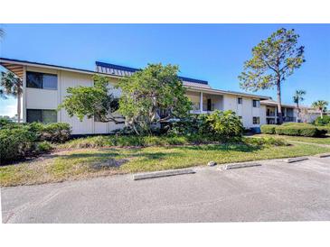 Inviting two-story condominium complex featuring a parking area and lush landscaping at 29230 Bay Hollow Dr # 3274, Wesley Chapel, FL 33543