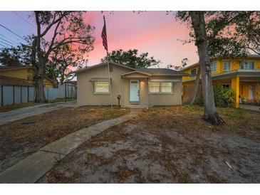 Charming single-story home featuring neutral paint and a pathway leading to the front door at sunset at 306 S Highland Ave, Clearwater, FL 33755