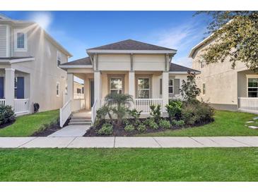 Charming home features a landscaped front yard and a covered front porch with white columns and railings at 724 Winterside Dr, Apollo Beach, FL 33572