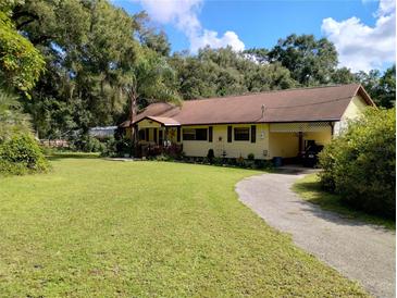 Charming single-story home with a well-manicured lawn and a long driveway at 7608 Chenkin, Zephyrhills, FL 33540