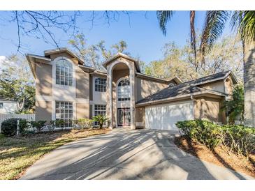 Two story home featuring an arched entryway, large windows, a two car garage and manicured landscaping at 9318 Heritage Oak Ct, Tampa, FL 33647
